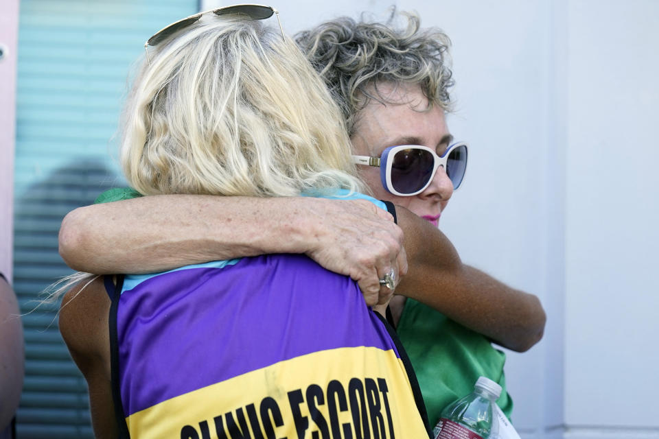 Diane Derzis, owner of the Jackson Women's Health Organization clinic in Jackson, Miss., right, hugs co-director of the clinic escorts, better known as the Pink House defenders, Derenda Hancock, at a news conference, following the U.S. Supreme Court ruling that overturned Roe v. Wade, Friday, June 24, 2022. The clinic is the only facility that performs abortions in the Mississippi. However, the ruling ends constitutional protections for abortion. (AP Photo/Rogelio V. Solis)