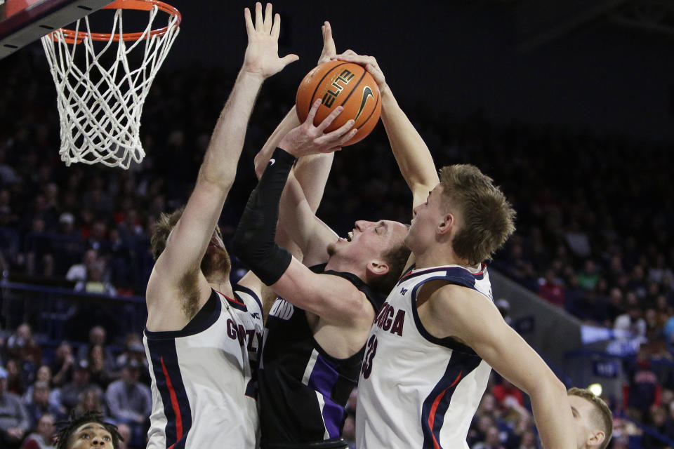 Gonzaga forward Ben Gregg, right, blocks a shot by Portland forward Moses Wood, center, while Gonzaga forward Drew Timme also defends during the first half of an NCAA college basketball game, Saturday, Jan. 14, 2023, in Spokane, Wash. (AP Photo/Young Kwak)