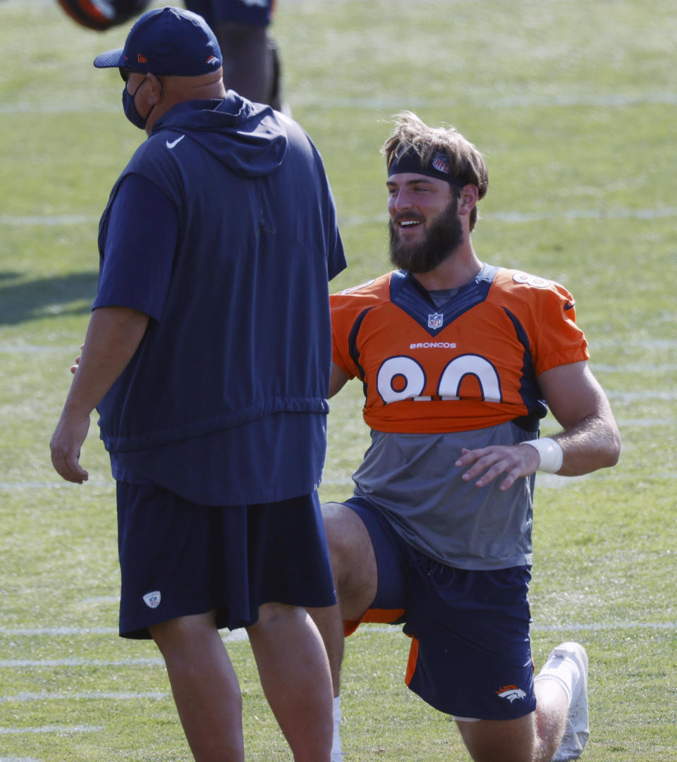 Denver Broncos tight end Jake Butt laughs as he stretches before taking part in drills during an NFL football practice at the team's headquarters Wednesday, Aug. 19, 2020, in Englewood, Colo. (AP Photo/David Zalubowski)