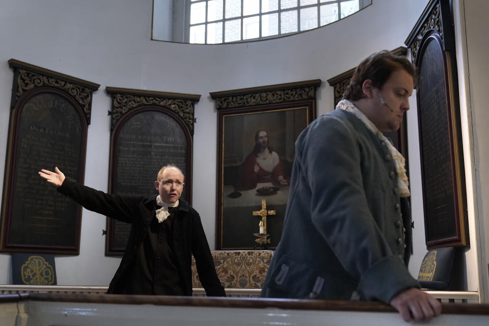 Actor Brooks Reeves, in the role of Mather Byles, left, performs with actor Evan Turissini, in the role of John Pulling, right, during a dress rehearsal of the play "Revolution's Edge" Monday, June 12, 2023, at Old North Church, in Boston's historic North End neighborhood. Old North Church, which played a pivotal role in the nation's fight for independence, and is one of Boston's most popular tourist attractions, will host a theater performance for the first time in the church's 300-year history. The 45-minute play opens Thursday, June 15. (AP Photo/Steven Senne)