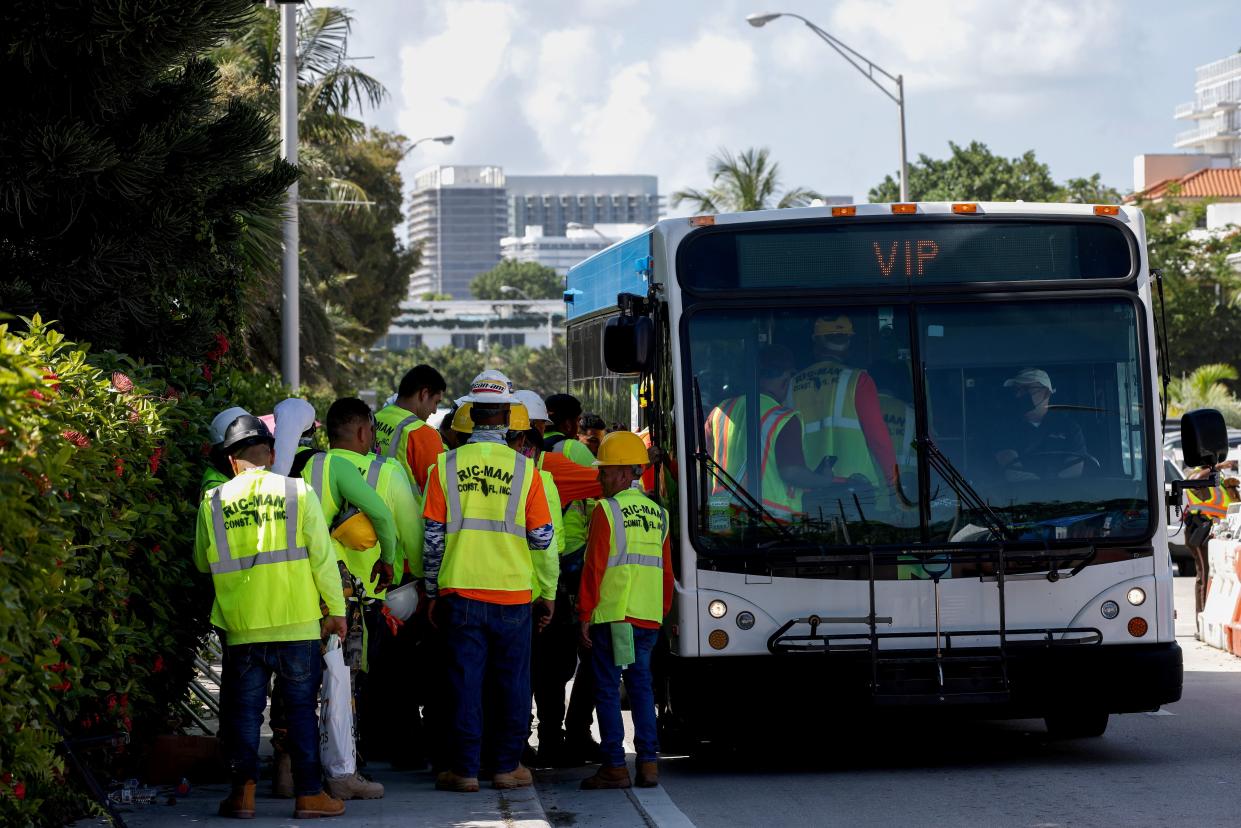 Rescue workers board a bus after a day's work at the collapsed 12-story Champlain Towers South condo building on July 11, 2021, in Surfside, Fla.