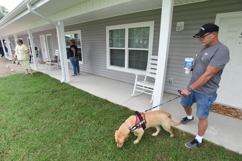 Jay Wilde stands with his service dog Simba outside of his apartment at the Nathaniel Smith Jr. House of Valor in Fort Walton Beach. Gregg Chapel A.M.E. Church has proposed developing an affordable housing complex in Crestview.