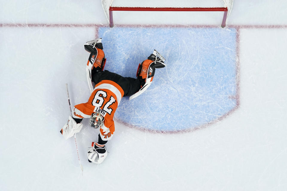 Philadelphia Flyers' Carter Hart covers up the puck during the first period of an NHL hockey game against the Detroit Red Wings, Sunday, March 5, 2023, in Philadelphia. (AP Photo/Matt Slocum)