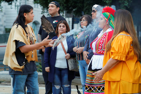 Andrew "Guiding Young Cloud" Morales (L) takes part in a sunrise celebration during the inaugural Indigenous People's Day in downtown Los Angeles after the Los Angeles City Council voted to establish the second Monday in October as "Indigenous People's Day", replacing Columbus Day, in Los Angeles, California, U.S., October 8, 2018. REUTERS/Mike Blake