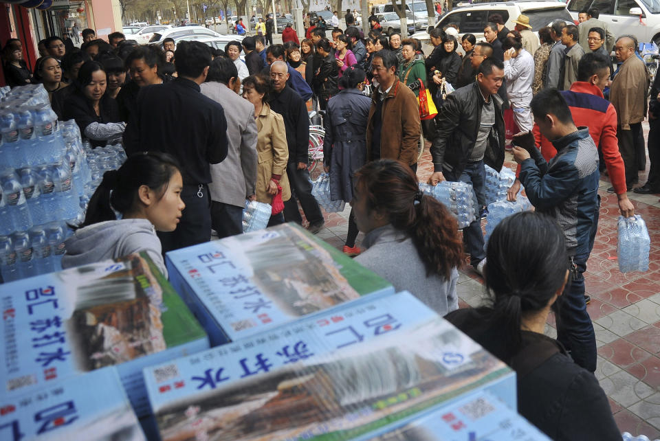 In this Friday, April 11, 2014 photo, people line up to buy bottled water in the northwestern city of Lanzhou, Gansu province, China. An oil pipe leak caused excessive levels of the toxic chemical benzene in a major Chinese city's water supply, prompting warnings against drinking from the tap and sending residents to queue up to buy bottled water. (AP Photo) CHINA OUT