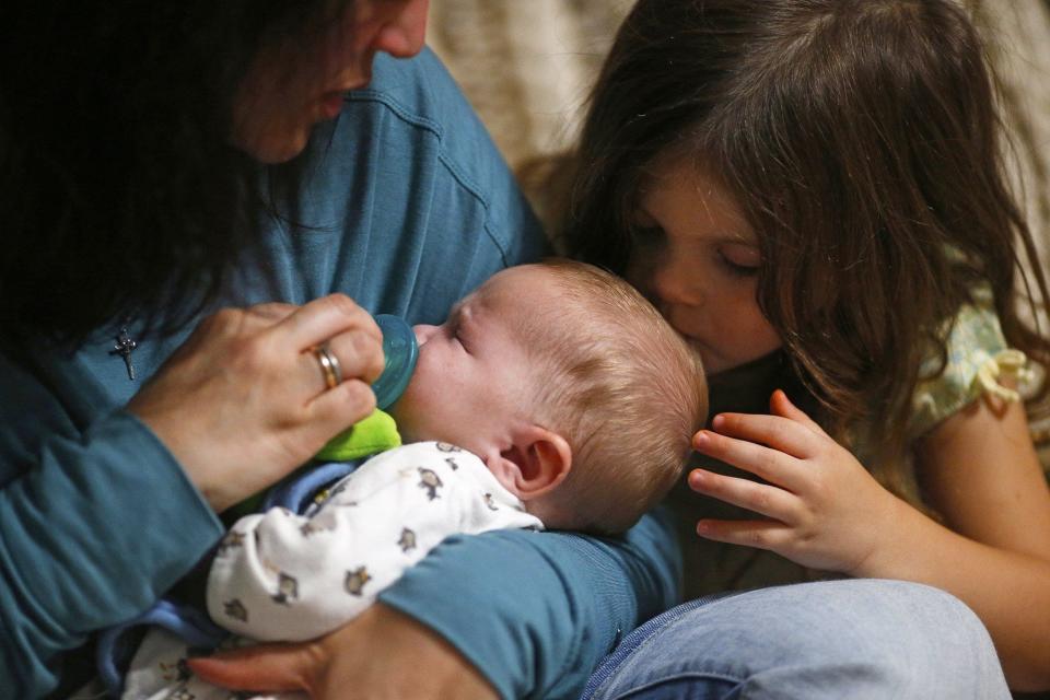 Stella Detwiler kisses the head of her baby brother, David, while mother Carlla watches. (Jeff Lange)