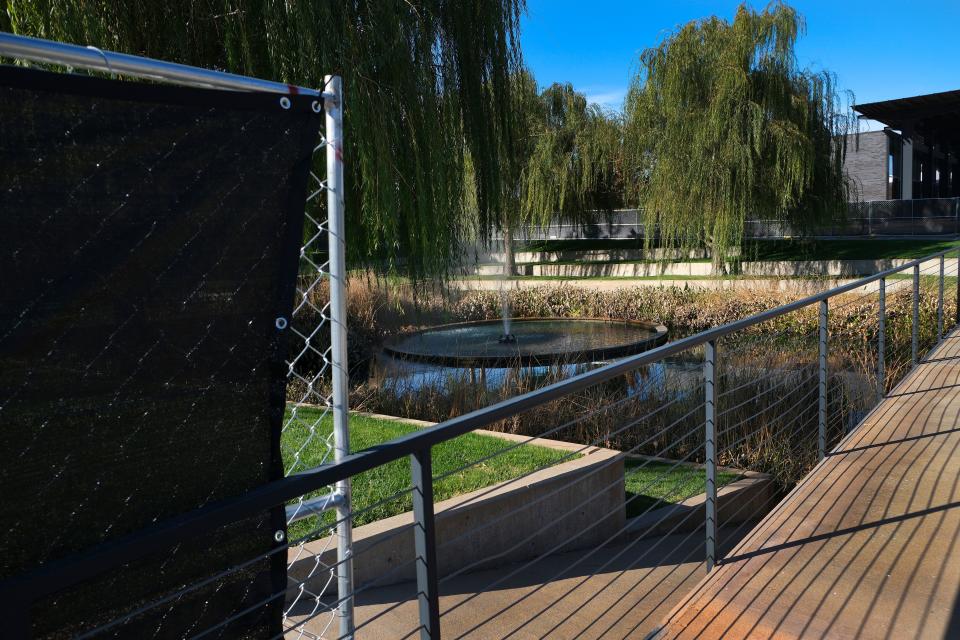 Temporary fencing blocks off part of the parking lot next to fountains set to be torn out to make way for a new retail building and parking.