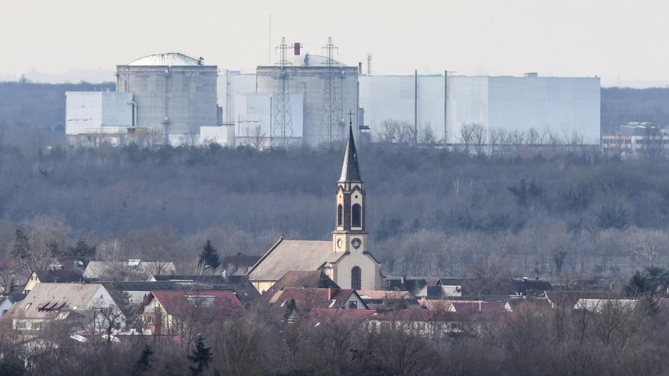 Der Kirchturm der katholischen Kirche St. Peter und Paul in deutschen Hartheim am Rhein ist vor dem Atomkraftwerk Fessenheim auf der französischen Seite der Grenze zu sehen.