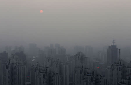 The sun sets above residential buildings on a hazy day in Beijing, September 20, 2014. REUTERS/Barry Huang