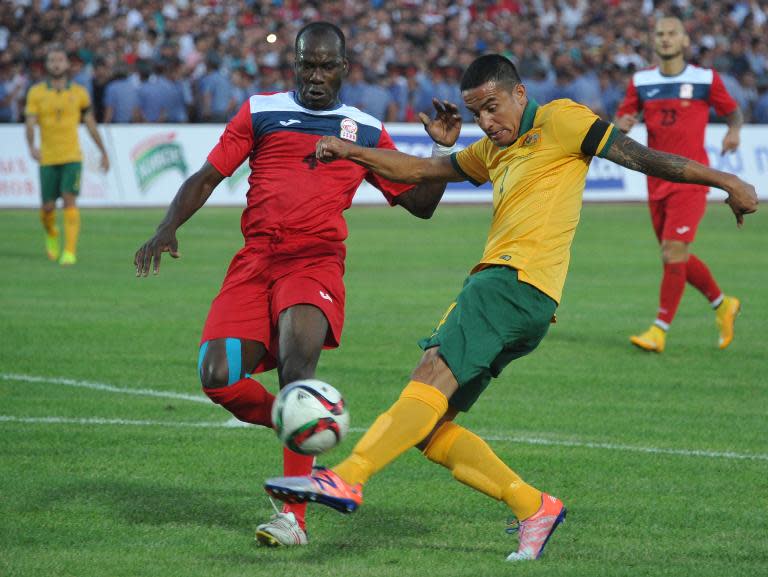 Kyrgyzstan's Daniel Tagoe (L) vies for the ball with Australia's Tim Cahill during the FIFA World Cup 2018 Group B qualifying football match between Kyrgyzstan and Australia in Bishkek on June 16, 2015