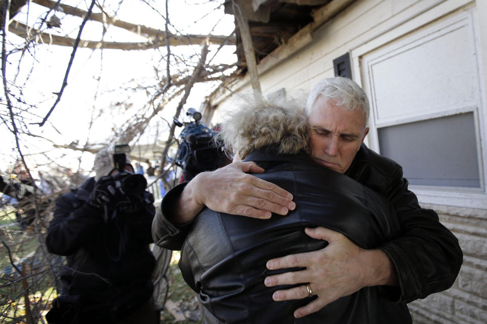 FILE - Indiana Gov. Mike Pence, right, hugs homeowner Patsy Addison in front of her storm-damaged home in Kokomo, Ind., Nov. 18, 2013. As Mike Pence approaches a likely 2024 run for president, he's opening up to audiences about the parts of his career before he served as Donald Trump's vice president. He hopes his 12 years in Congress and four years as Indiana governor will project the record of a conservative fighter. (AP Photo/AJ Mast, File)