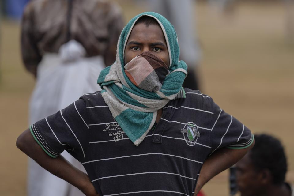 A protester waits and watches troops stand guard following an eviction of protesters from the presidential secretariat in Colombo, Sri Lanka, Friday, July 22, 2022. (AP Photo/Eranga Jayawardena)