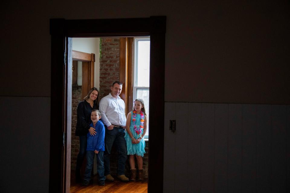 Rod Williams II (white shirt) stands with his wife Abbey Williams (left) and their children Eli, 7, and Evy, 10, inside one the properties they own through their real estate company, Boon Properties, along North Broad Street on Feb. 20, 2023 in Lancaster, Ohio. The Williams Family on United Airlines Flight 1722 when it took a mysterious nose dive when the plane was leaving Maui heading for San Francisco. 