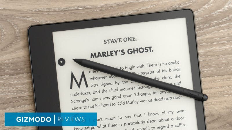 The Amazon Kindle Scribe sitting on a wooden desk with its Premium Pen stylus sitting on the screen.