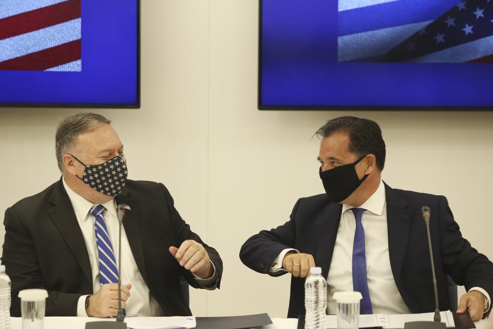 U.S. Secretary of State Mike Pompeo, left and Greek Minister for Development and Investment Adonis Georgiadis touch elbows during a signing agreement ceremony in the northern city of Thessaloniki, Greece, Monday, Sept. 28, 2020. Tension in the eastern Mediterranean is to feature prominently during Pompeo's two-day stay in Greece, which will include a visit to the Souda Bay naval base on the southern island of Crete Tuesday. (AP Photo/Giannis Papanikos, Pool)