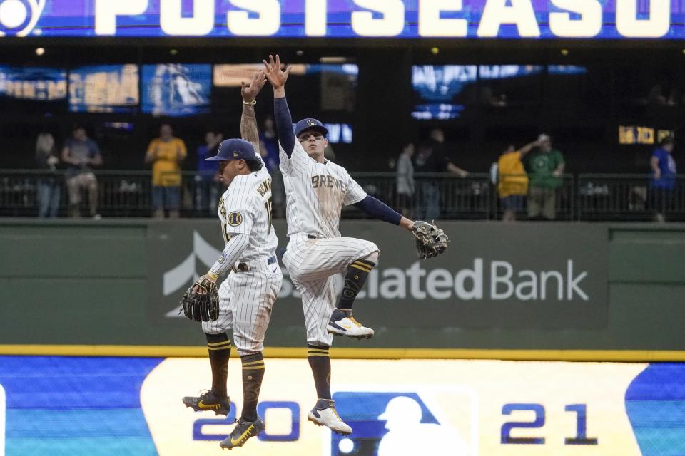 Milwaukee Brewers' Kolten Wong and Luis Urias celebrate after a baseball game against the Chicago Cubs Saturday, Sept. 18, 2021, in Milwaukee. The Brewers won 6-4 and clinched a spot in the 2021 Postseason. (AP Photo/Morry Gash)