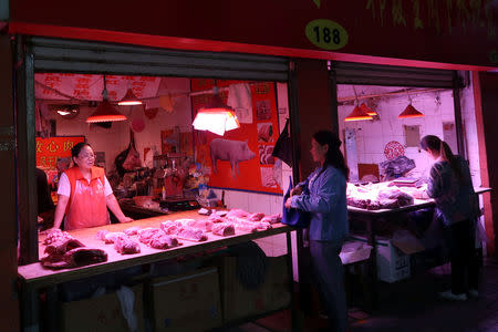 A customer visits a pork stall at a market on the outskirts of Harbin, Heilongjiang province, China September 5, 2018. REUTERS/Hallie Gu