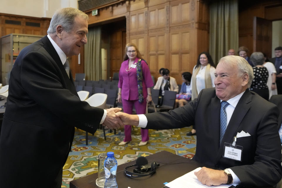 Nicaragua's agent Carlos Jose Arguello Gomez, left, greets Colombia's agent Eduardo Valencia Ospina, right, at the World Court in The Hague, Netherlands, Thursday, July 13, 2023, where the United Nations' highest court delivered its judgment in a long-running maritime border dispute between Nicaragua and Colombia. (AP Photo/Peter Dejong)