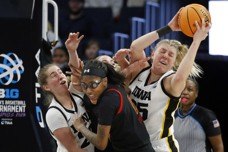 Iowa guard Kate Martin, left, and Iowa forward Monika Czinano, right, and Maryland guard Shyanne Sellers, center, compete for a rebound in the second half of an NCAA college basketball game at the Big Ten women's tournament Saturday, March 4, 2023, in Minneapolis. Iowa won 89-84. (AP Photo/Bruce Kluckhohn)