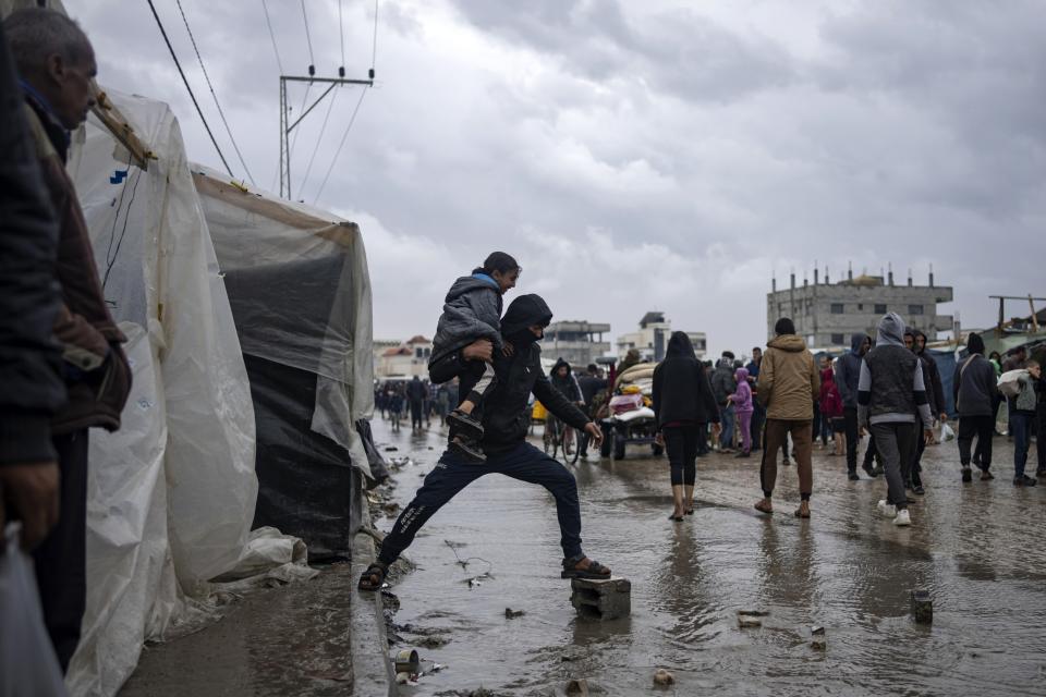 FILE - Palestinians displaced by the Israeli air and ground offensive on the Gaza Strip walk through a makeshift tent camp in Rafah on Jan. 27, 2024. The tent camps stretch for more than 16 kilometers (10 miles) along Gaza’s coast, filling the beach and sprawling into empty lots, fields and town streets. (AP Photo/Fatima Shbair, file)