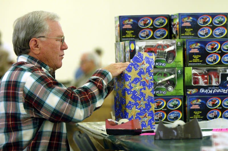 Salvation Army volunteer Ed Wizeman secures wrapping paper on a Christmas gift using Scotch tape during the first day of the Salvation Army's Toy Lift in St. Louis on November 30, 2004. On May 27, 1930, Richard Gurley Drew received a patent for his adhesive tape, which was later manufactured by 3M as Scotch tape. File Photo by Bill Greenblatt/UPI