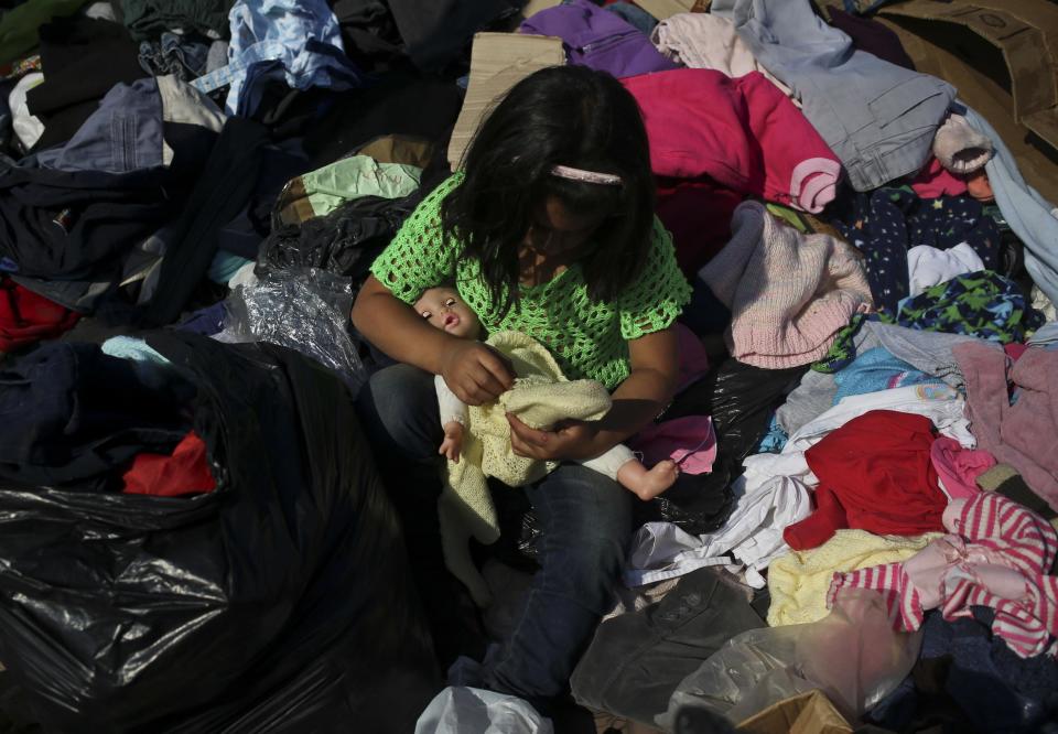 Jenny Tapia dresses her doll with clothes donated to victims of Chile's raging wildfires, in the community of Santa Olga, Chile, Tuesday, Jan. 31, 2017. Flames from one of the country's worst wildfires completely consumed the town of Santa Olga. (AP Photo/Esteban Felix)