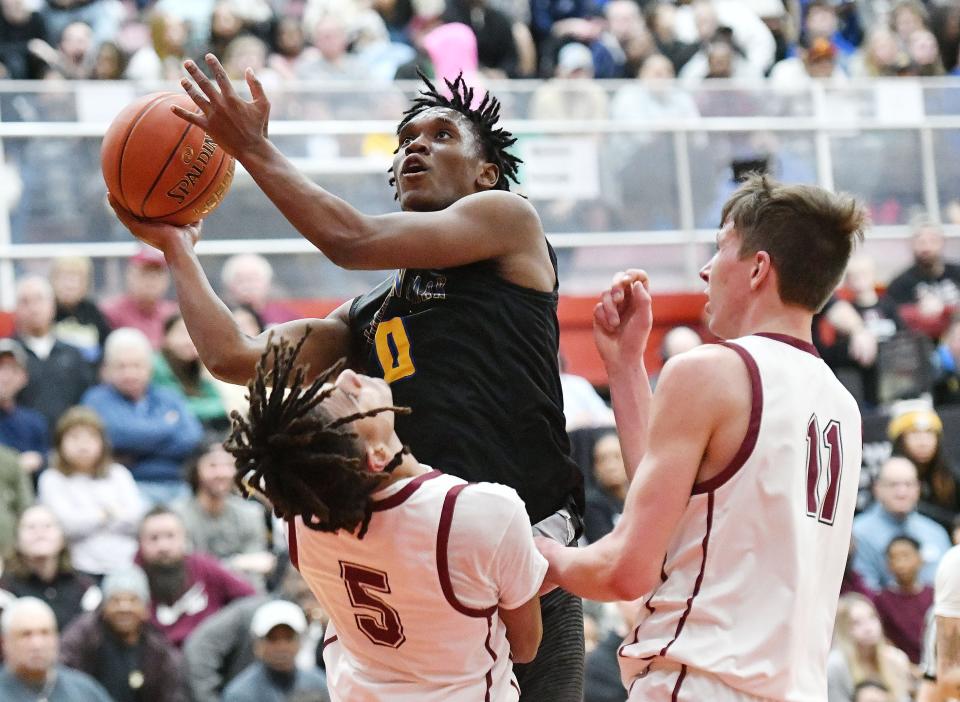 Lincoln Park's Dontay Green shoots over Uniontown's Bakari Wallace and Levi Garner during Monday's PIAA Class 4A semifinal game at Charleroi High School.