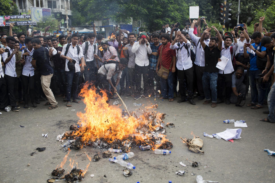Bangladeshi students burn an effigy of Bangladesh's Shipping Minister Shahjahan Khan, who is also a transport workers' leader, as they block a road during a protest in Dhaka, Bangladesh, Wednesday, Aug. 1, 2018. Students blocked several main streets in the capital, protesting the death of two college students in a bus accident in Dhaka. (AP Photo/A. M. Ahad)