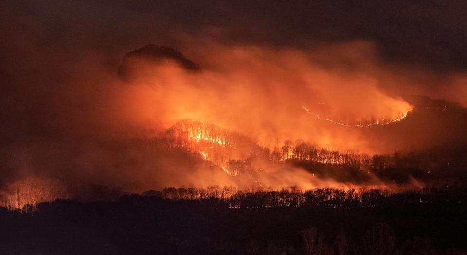 Smoke envelopes the landmark pinnacle (top left) as a wildfire burns on the north side of the mountain at Pilot Mountain State Park on Sunday, Nov. 28, 2021. Extremely dry conditions also have increased the risk of fire in the Charlotte area, the National Weather Service warned on Monday.