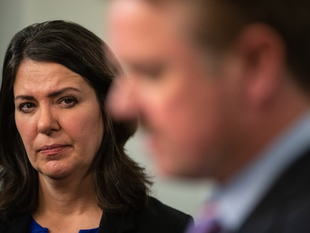 Alberta Premier Danielle Smith looks on as Justice Minister Tyler Shandro addresses reporters in November 2022. Sources told CBC News the premier was pressuring Shandro and his staff to abandon pandemic-related prosecutions in the province. (Jason Franson/The Canadian Press - image credit)