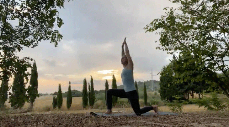 Woman practicing an early morning yoga routine in low lunge with her thumbs hooked