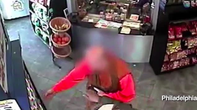 The suspect's hand can be seen reaching to snatch the wallet out of the monk's hand. Photo: Philadelphia Police