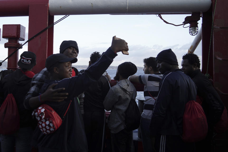 A couple takes a selfie as they wait to disembark from aboard the Ocean Viking ship as it reaches the port of Messina, Italy, Tuesday, Sept. 24, 2019. The humanitarian ship has docked in Italy to disembark 182 men, women and children rescued in the Mediterranean Sea after fleeing Libya. (AP Photo/Renata Brito)