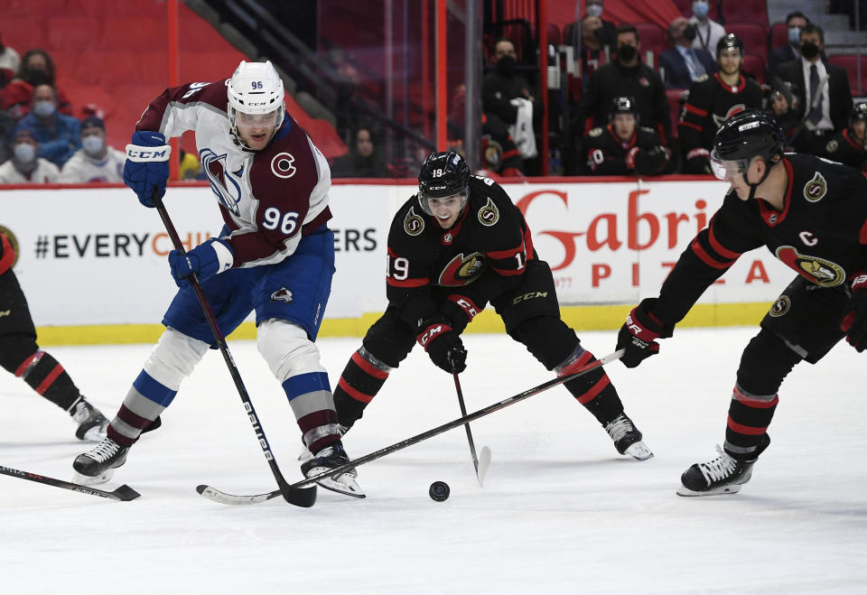 Ottawa Senators right wing Drake Batherson (19) and left wing Brady Tkachuk work to take the puck from Colorado Avalanche right wing Mikko Rantanen (96) during the third period of an NHL hockey game Saturday, Dec. 4, 2021, in Ottawa, Ontario. (Justin Tang/The Canadian Press via AP)