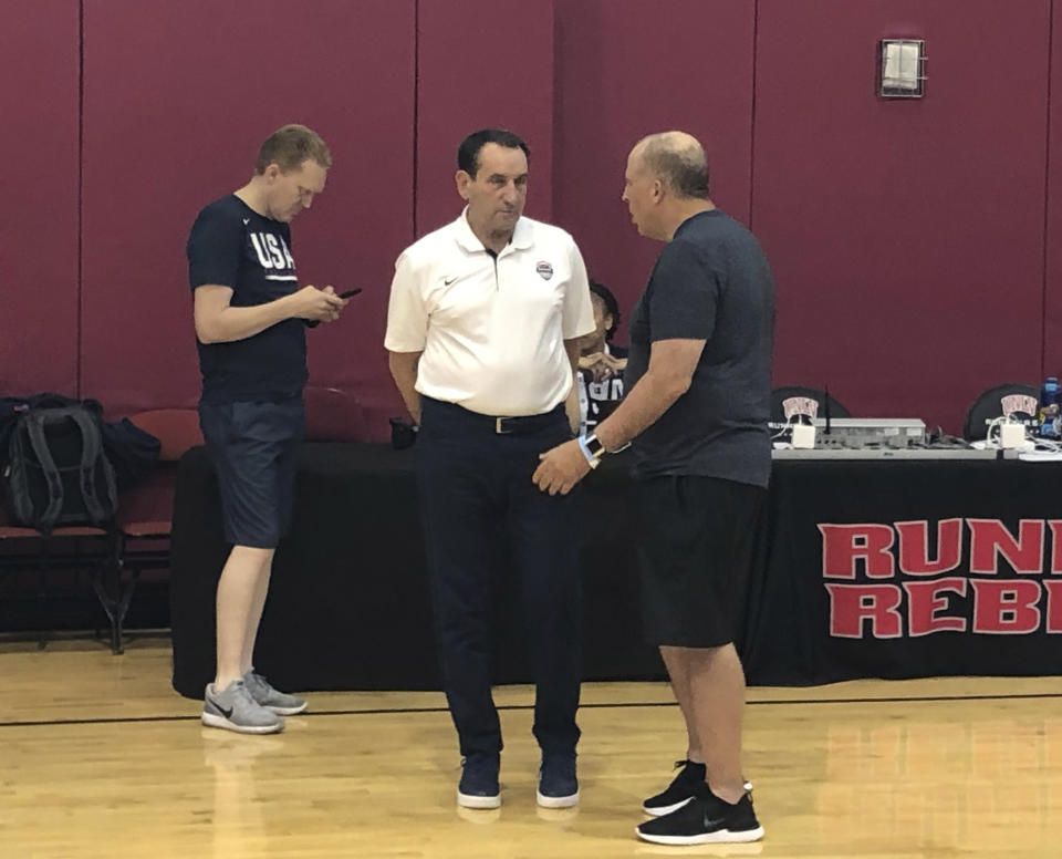 Former USA Basketball coach Mike Krzyzewski, center, talks with former NBA coach Tom Thibodeau after the U.S. basketball training camp practice Wednesday, Aug 7 2019. Krzyzewski is in Las Vegas for a couple days to show support to new coach Gregg Popovich and his staff as they prepare for the FIBA World Cup in China. (AP Photo/Tim Reynolds)