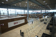 People walk through the Terminal 1 of the new Berlin-Brandenburg-Airport 'Willy Brandt' near Berlin in Schoenefeld, Germany, Tuesday, Oct. 27, 2020. After years of delays and massive cost overruns the opening of the German capital's new airport is scheduled for Saturday Oct. 31.(AP Photo/Markus Schreiber)