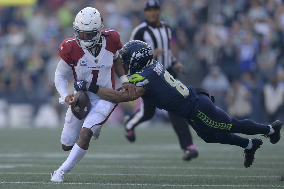 Arizona Cardinals quarterback Kyler Murray (1) fumbles while tackled by Seattle Seahawks cornerback Coby Bryant, right, during the second half of an NFL football game in Seattle, Sunday, Oct. 16, 2022. The ball was recovered by Seahawks cornerback Tariq Woolen. (AP Photo/Caean Couto)