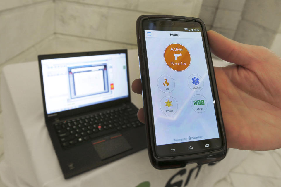 FILE - A smartphone is held during a demonstration of the Rave Panic Button application at the Arkansas state Capitol in Little Rock, Ark., Aug. 11, 2015. The system is designed to enable authorities to respond to crises faster across more than 1,000 public schools in Arkansas. In the wake of a deadly elementary school shooting in Tennessee earlier this week, state lawmakers across the country are moving forward with school safety measures. (AP Photo/Danny Johnston, File)