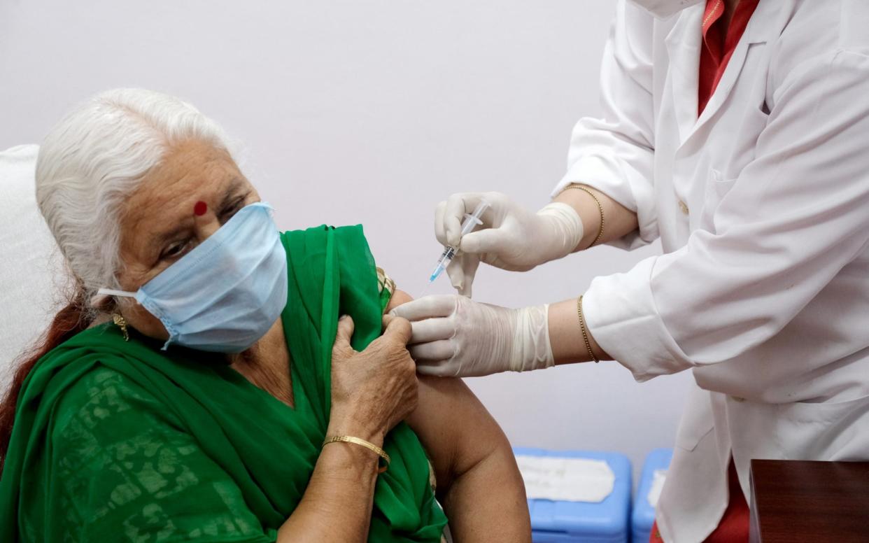 A health worker administers the AstraZeneca vaccine to a senior citizen in New Delhi - T. Narayan /Bloomberg