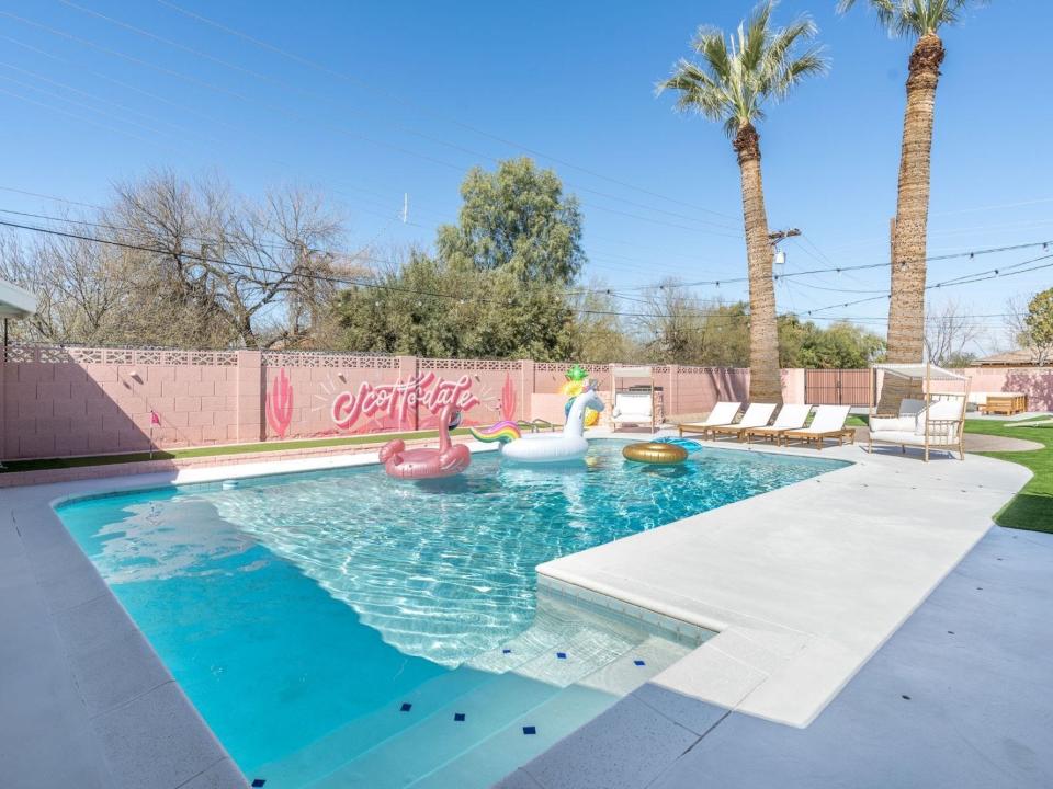 A pool surrounded by a pink fence.