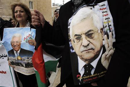 Palestinians hold posters depicting President Mahmoud Abbas during a rally in the West Bank town of Bethlehem March 17, 2014. REUTERS/Ammar Awad