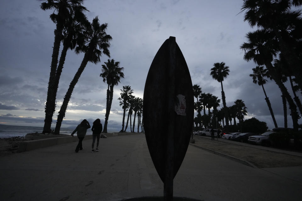 People walk on the San Buenaventura Beach Trail ahead of storms in Ventura, Calif., Wednesday, Jan. 31, 2024. (AP Photo/Damian Dovarganes)