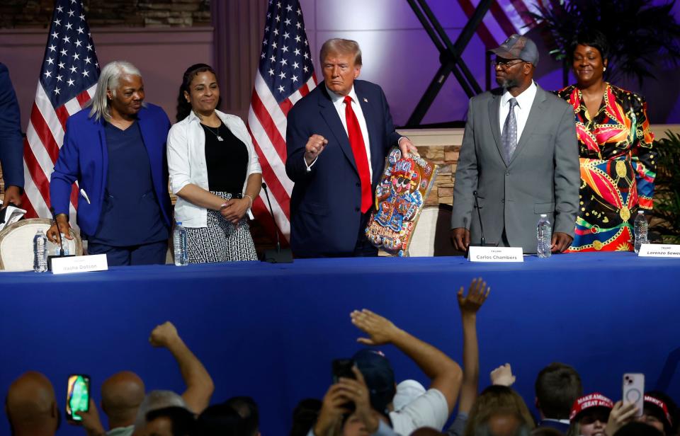 Former President Donald Trump shows off the decorated birthday cake cookie that was given to him after the crowd sang happy birthday to him following the roundtable discussion inside the 180 Church in Detroit on Saturday, June 15, 2024.