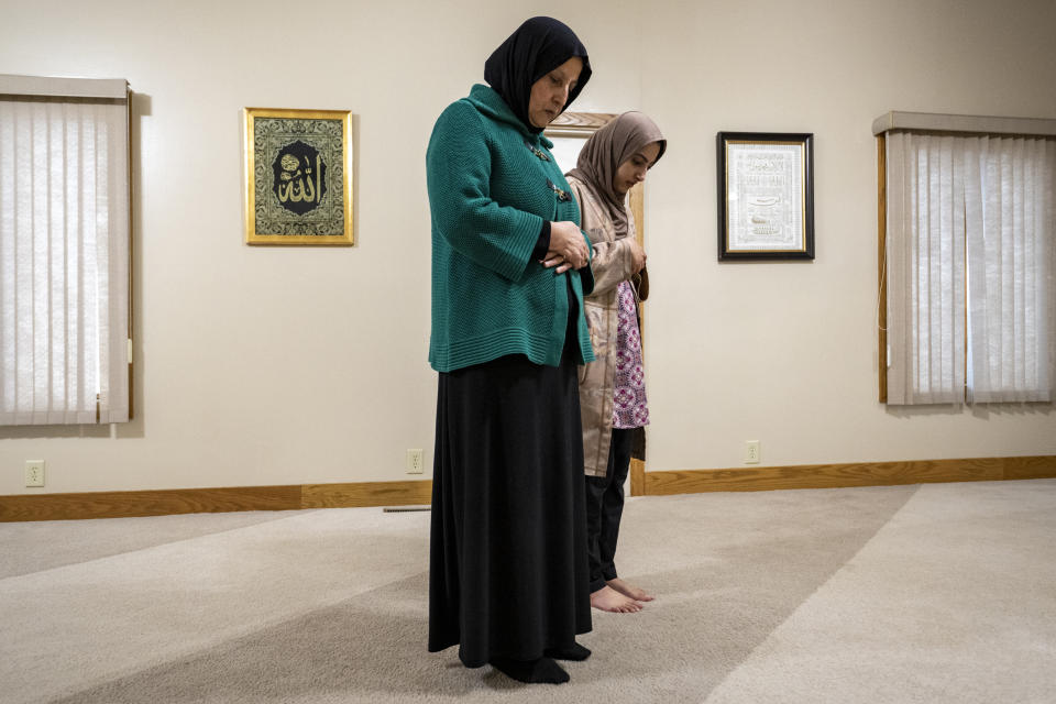 Bibi Bahrami, foreground, prays at the Islamic Center of Muncie, Ind., on Friday, March 3, 2023, where she is one of the mosque's leaders. Bahrami is a subject of the documentary "Stranger at the Gate" that tells the story of the relationship she and others in their small Islamic community fostered with Richard McKinney, a former U.S. Marine who at one point had planned to bomb their community center. (AP Photo/Doug McSchooler)