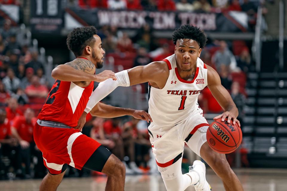 Texas Tech's Terrence Shannon, Jr. (1) dribbles the ball around Lamar's Casey Brooks (22) during the second half of an NCAA college basketball game Saturday, Nov. 27, 2021, in Lubbock, Texas.
