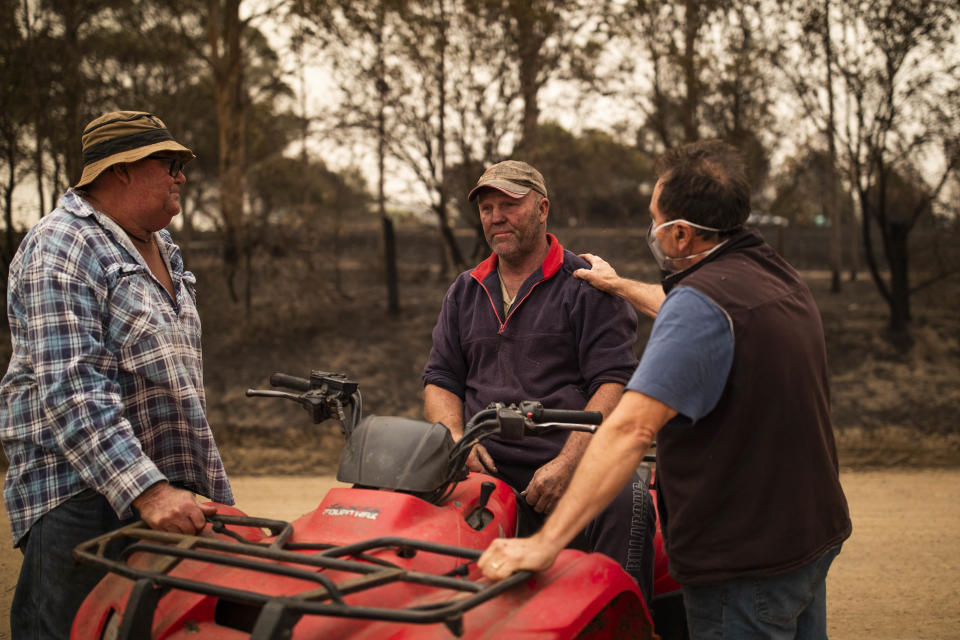 Steve Shipton (centre) is consoled by fellow farmers Bernie Smith (left) and Peter Mercieca in Coolagolite, NSW, Wednesday, January 1, 2020. Source: AAP