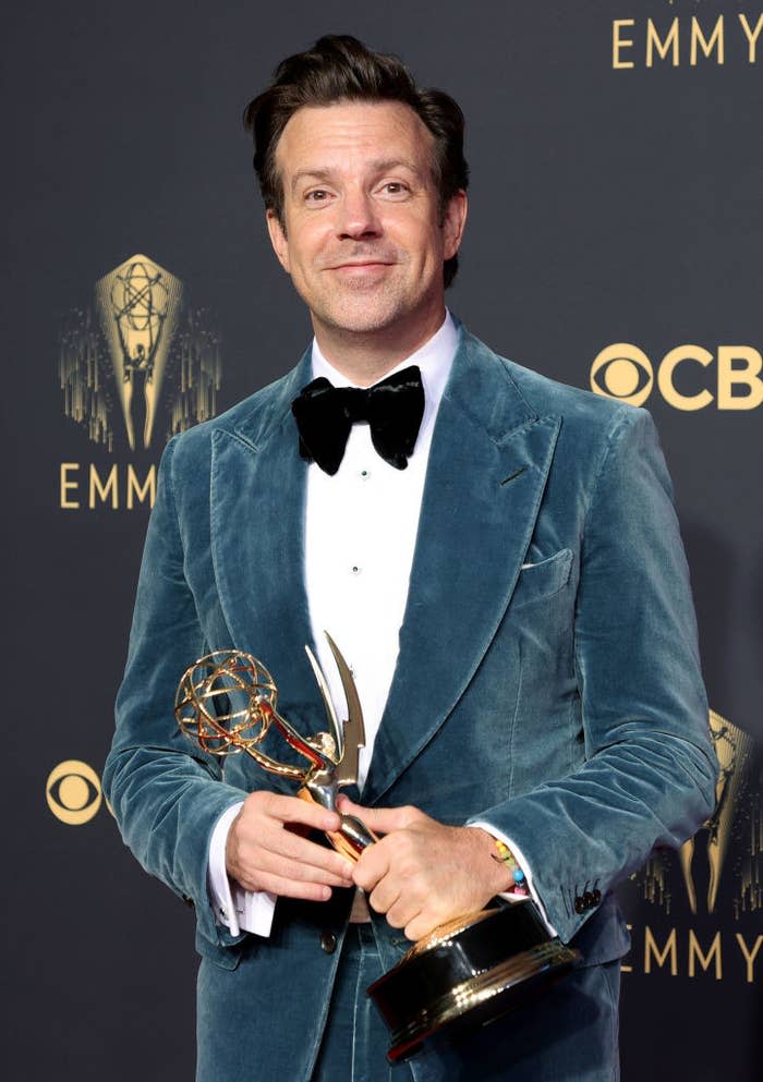 Jason Sudeikis on a red carpet holding an award