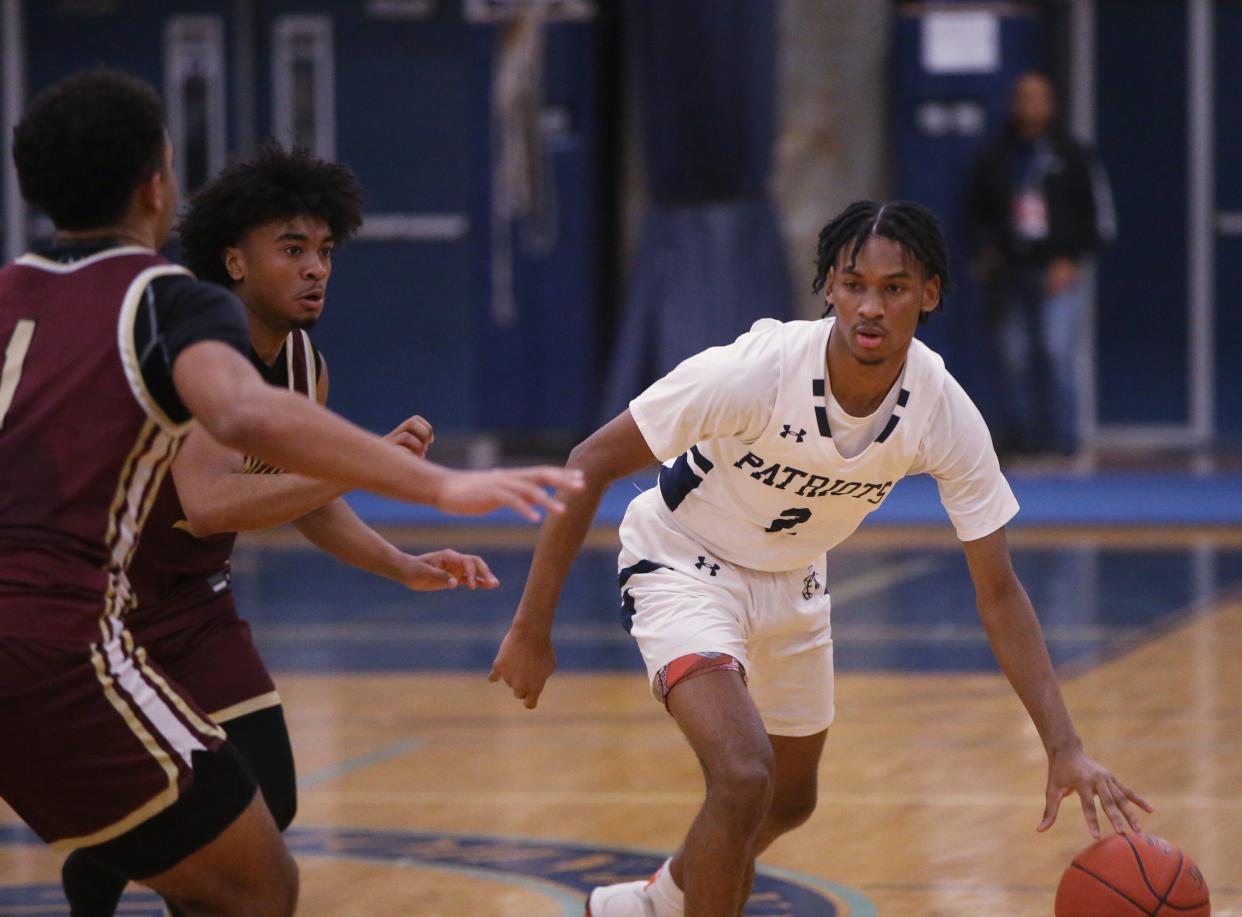 John Jay's Gavyn Pacheco dribbles away from Arlington's Jensy Adames and Jacob Jerome during a game on February 8, 2024.