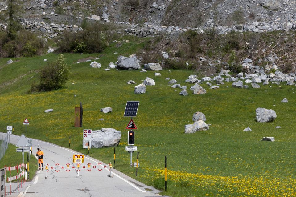 road is closed where rocks have fallen on the grass in Brienz-Brinzauls, Switzerland