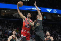 Chicago Bulls forward Dalen Terry (25) shoots over Washington Wizards guard Johnny Davis, center right, during the first half of an NBA basketball game Friday, April 12, 2024, in Washington. (AP Photo/Mark Schiefelbein)